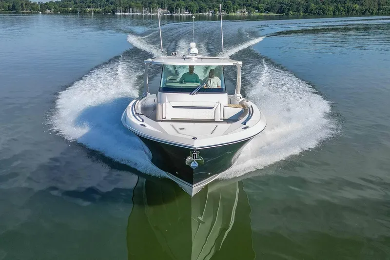 Slide: The Image of 2024 Tiara Yachts 38 LS cruising on a serene lake, creating a dynamic water trail. - 9