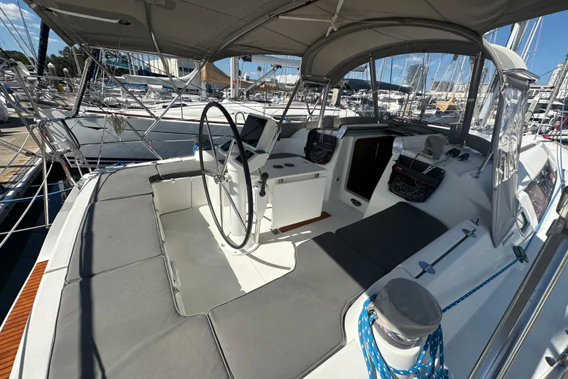 Slide: The Image of 2013 Beneteau Oceanis 37 sailboat cockpit with steering wheel and seating, docked at marina. - 10