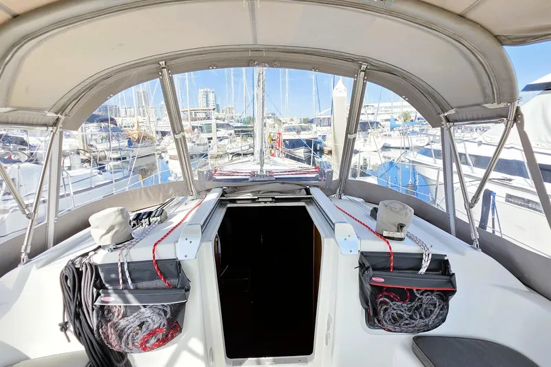Slide: The Image of Cockpit view of 2013 Beneteau Oceanis 37 sailboat in marina, showcasing covered seating area. - 18