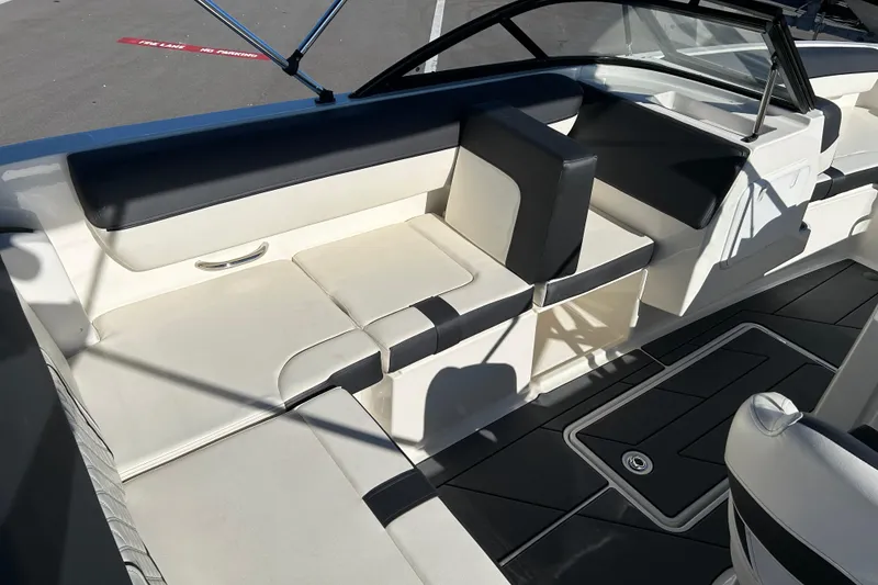 Slide: The Image of 2020 Bayliner DX 2000 boat interior with white and black seating and flooring. - 12