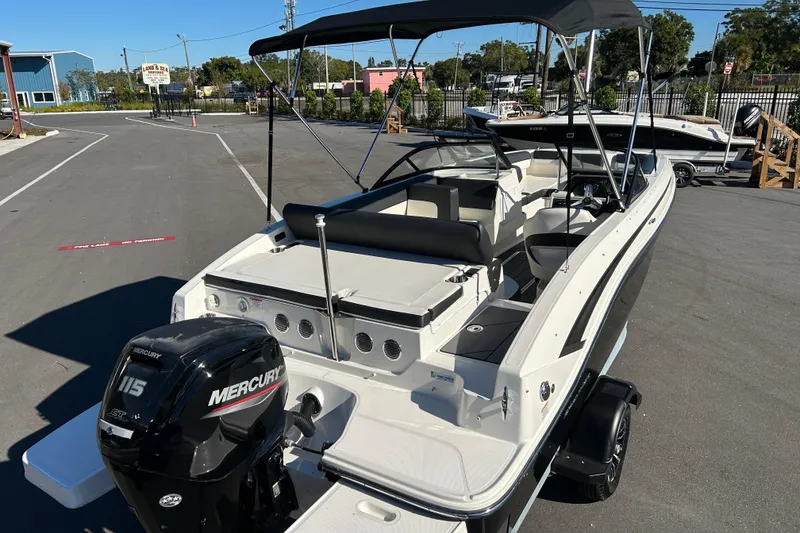 Slide: The Image of 2020 Bayliner DX 2000 boat with Mercury 115 engine, parked outdoors under clear sky. - 7