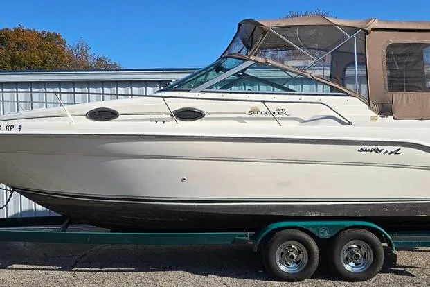 Slide: The Image of 1999 Sea Ray 270 Sundancer boat on trailer, side view, parked outdoors. - 29
