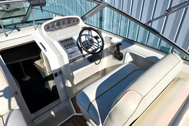 Slide: The Image of 1999 Sea Ray 270 Sundancer cockpit with steering wheel and control panel. - 4