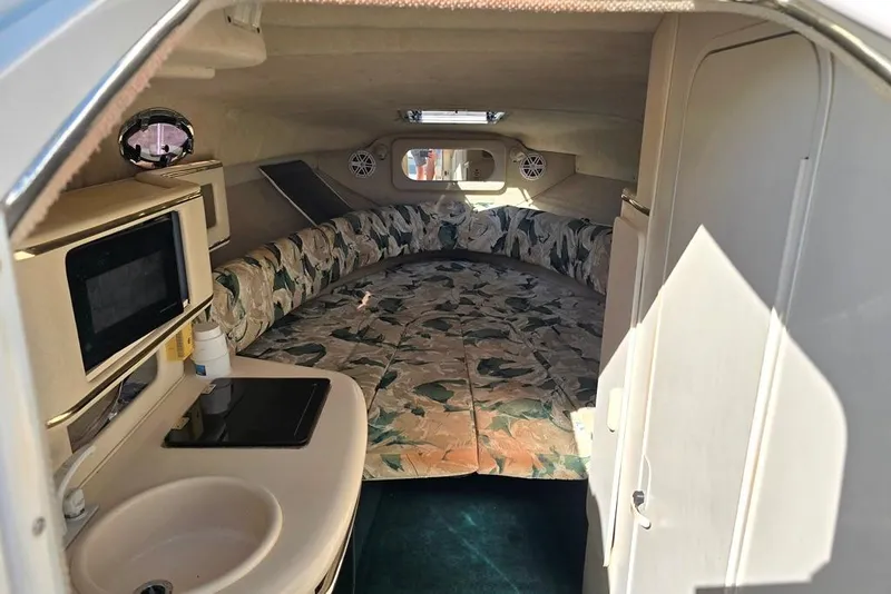 Slide: The Image of Interior of 1999 Sea Ray 270 Sundancer boat with kitchenette and seating area. - 5