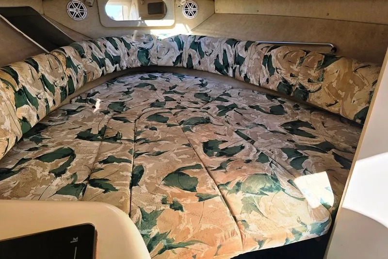 Slide: The Image of 1999 Sea Ray 270 Sundancer cabin interior with floral-patterned seating and bedding. - 6