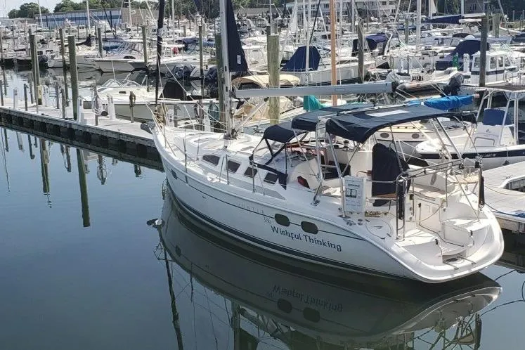 The Image of 2004 Hunter 386 sailboat docked in a marina, surrounded by other boats. - 0