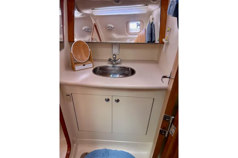 Slide: The Image of 2004 Hunter 386 yacht bathroom with sink, mirror, and storage cabinet. - 10