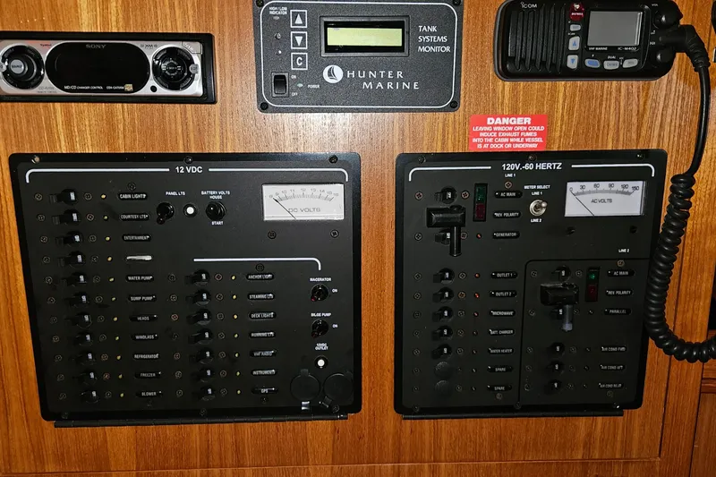 Slide: The Image of Electrical control panel on a 2004 Hunter 386 sailboat, featuring various switches and meters. - 15