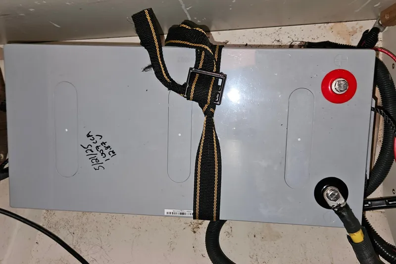 Slide: The Image of 12V battery in Hunter 386, 2004 model, secured with strap and labeled. - 19