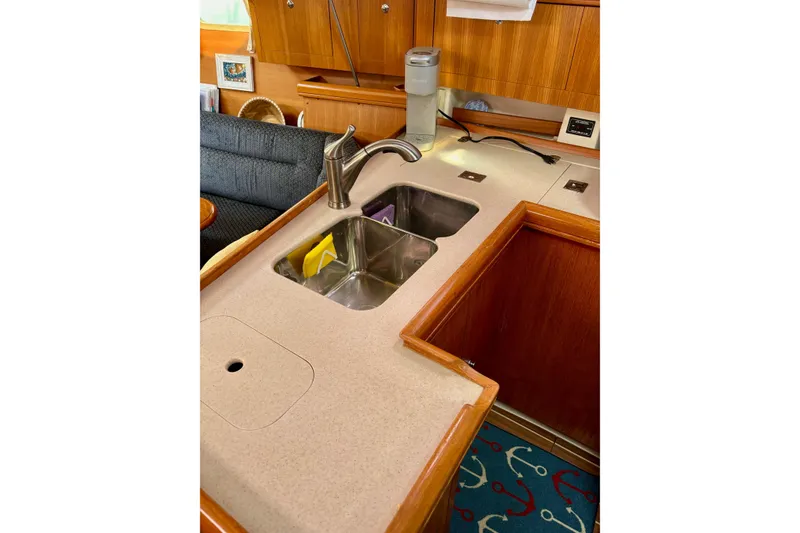 Slide: The Image of 2004 Hunter 386 yacht kitchen with sink, faucet, and wooden cabinetry. - 7