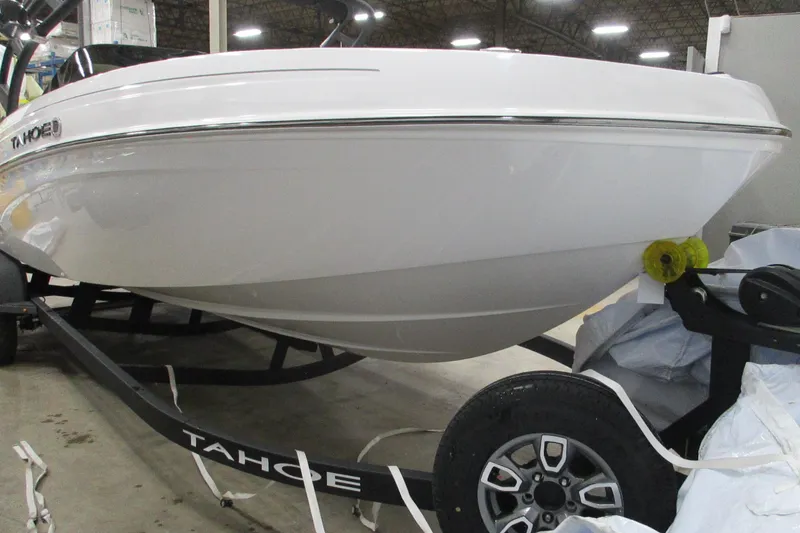 Slide: The Image of 2025 Tahoe T21 boat on trailer in warehouse setting. - 2