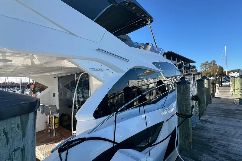 Slide: The Image of 2022 Sunseeker Manhattan 55 yacht docked at a marina under clear blue skies. - 10