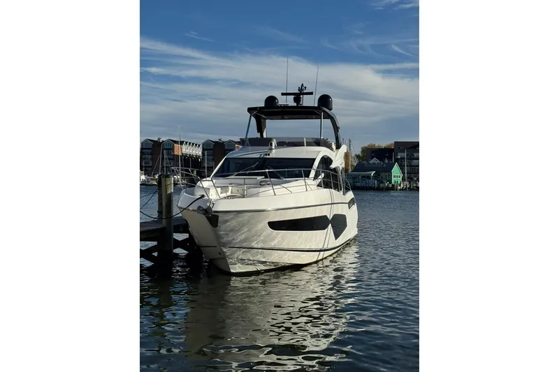 Slide: The Image of 2022 Sunseeker Manhattan 55 yacht docked in a marina, under a clear blue sky. - 15