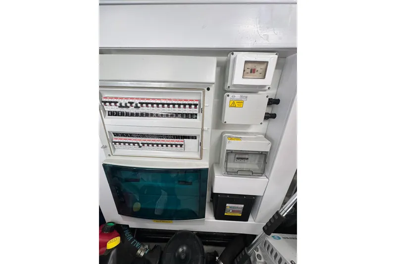 Slide: The Image of Electrical panel on a 2022 Sunseeker Manhattan 55 yacht, featuring circuit breakers and control boxes. - 32