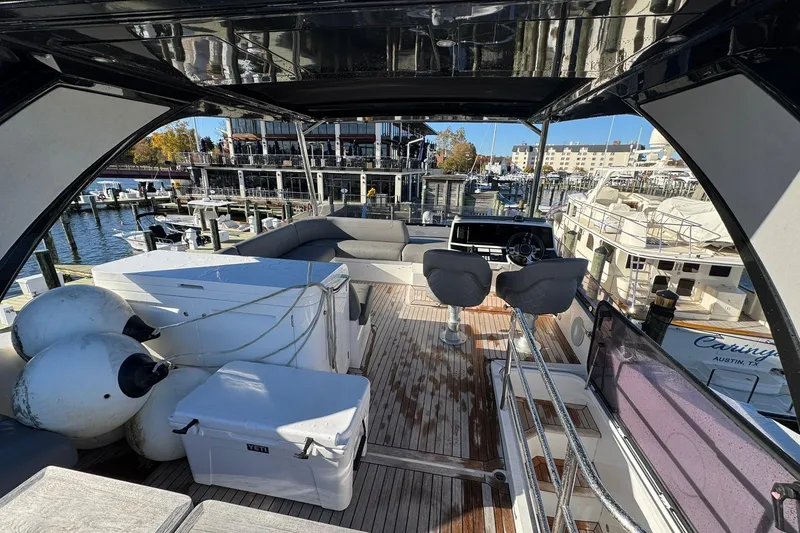 Slide: The Image of 2022 Sunseeker Manhattan 55 yacht interior with seating and helm, docked at marina. - 4