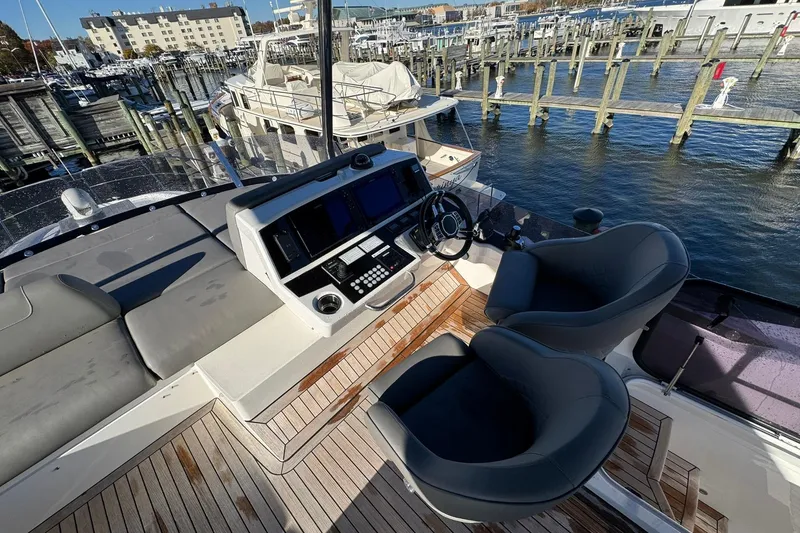 Slide: The Image of Flybridge of 2022 Sunseeker Manhattan 55 yacht with helm station and seating, docked at marina. - 6