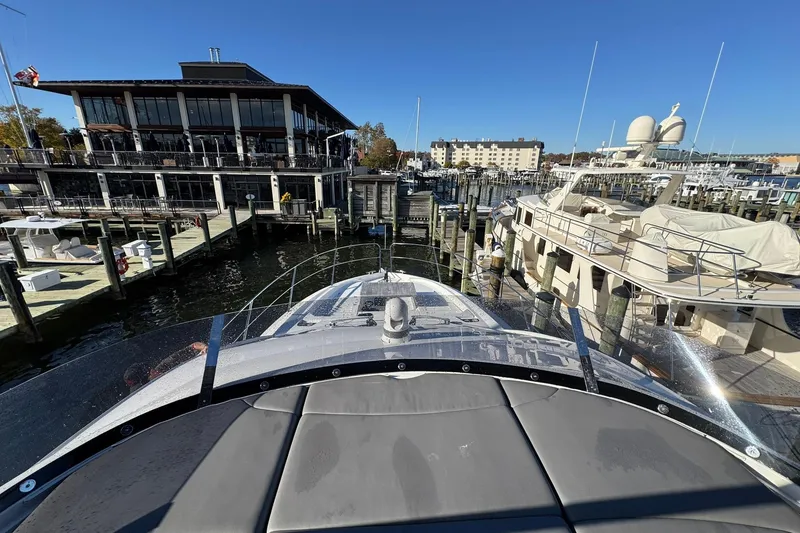 Slide: The Image of 2022 Sunseeker Manhattan 55 yacht docked at a marina with waterfront buildings. - 7