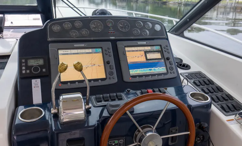 Slide: The Image of 2005 Tiara Yachts 3600 Sovran helm with dual navigation screens and wooden steering wheel. - 18