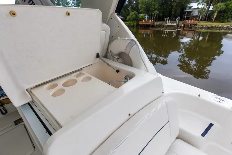 Slide: The Image of 2005 Tiara Yachts 3600 Sovran boat interior with sink and cup holders by a lake. - 25