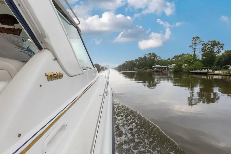 Slide: The Image of 2005 Tiara Yachts 3600 Sovran cruising on a serene river under a blue sky. - 28