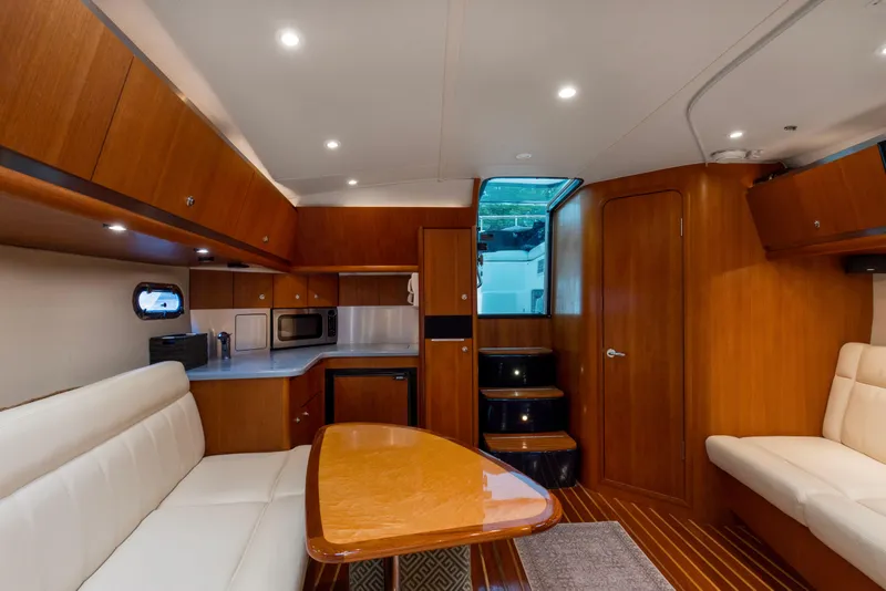 Slide: The Image of 2005 Tiara Yachts 3600 Sovran interior with wood finish, dining area, and kitchenette. - 3