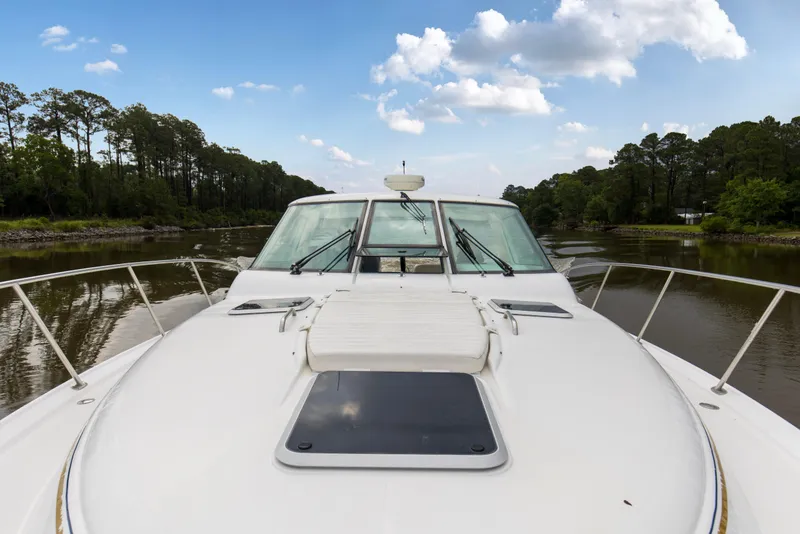 Slide: The Image of 2005 Tiara Yachts 3600 Sovran cruising on a serene river under a blue sky. - 31