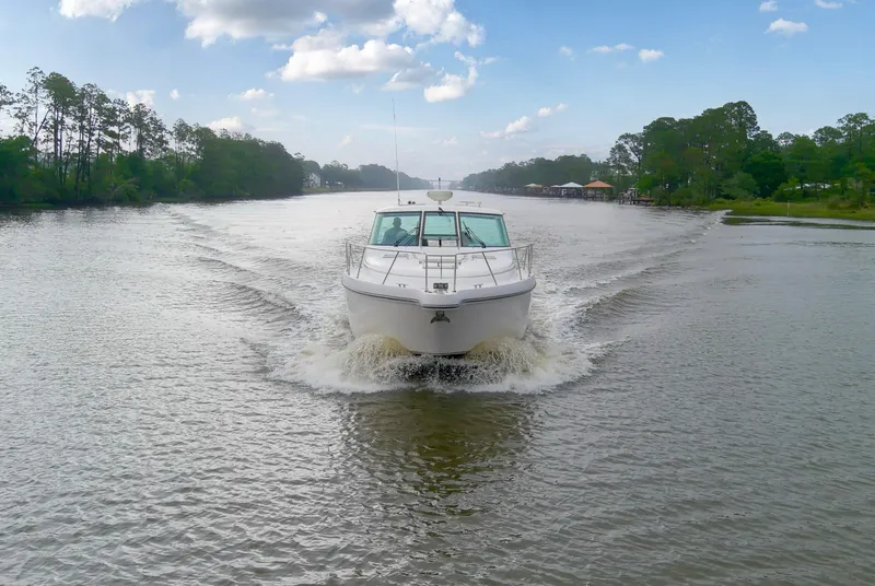 Slide: The Image of 2005 Tiara Yachts 3600 Sovran cruising on a scenic river under a partly cloudy sky. - 33