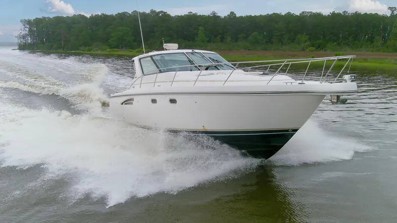 Slide: The Image of 2005 Tiara Yachts 3600 Sovran cruising on a river with lush green forest backdrop. - 37