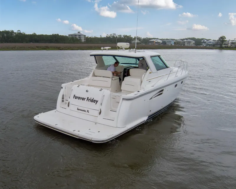 Slide: The Image of 2005 Tiara Yachts 3600 Sovran cruising on a calm river under a blue sky. - 39
