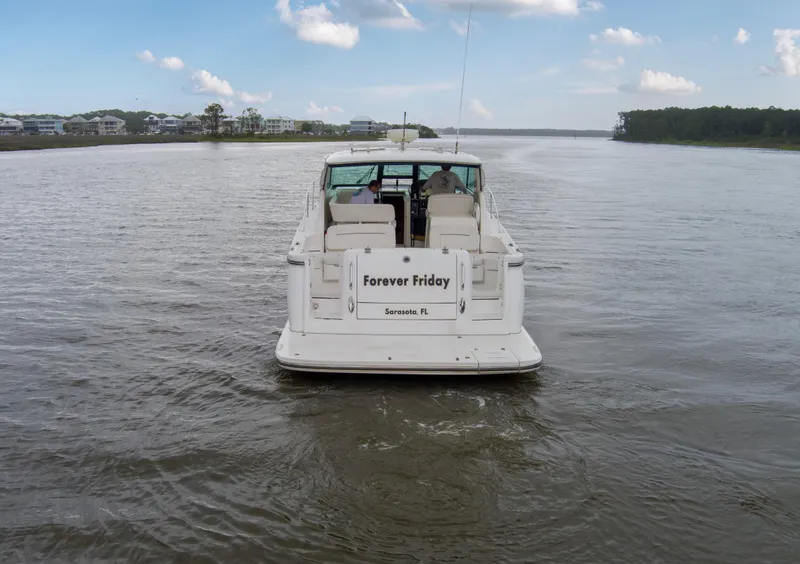 Slide: The Image of 2005 Tiara Yachts 3600 Sovran cruising on a calm river under a blue sky. - 43