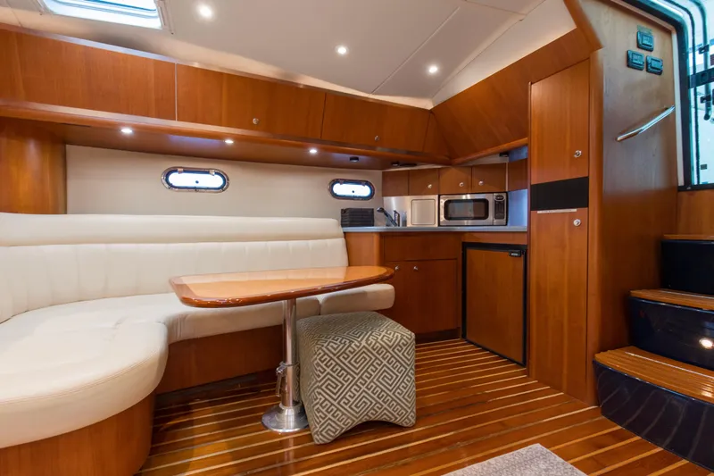 Slide: The Image of 2005 Tiara Yachts 3600 Sovran interior with wood finish, kitchenette, and seating area. - 5