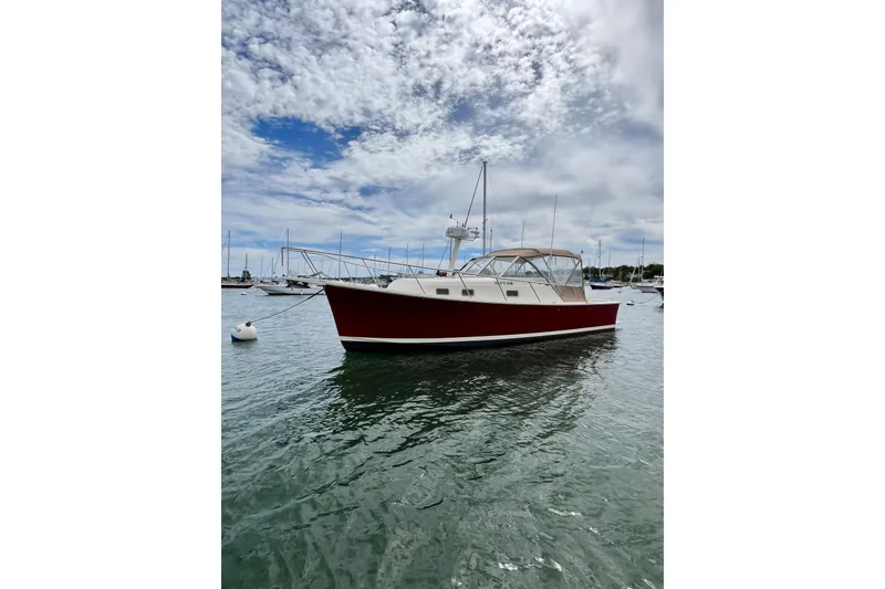 The Image of 2005 Mainship Pilot 30-II boat on calm water under a cloudy sky. - 0