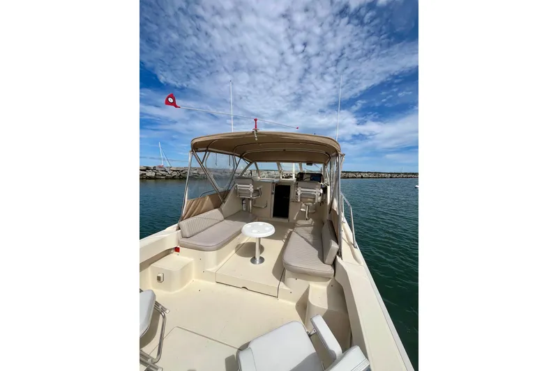 Slide: The Image of 2005 Mainship Pilot 30-II boat with spacious deck and seating under a clear sky. - 21