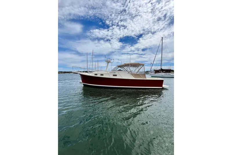 Slide: The Image of 2005 Mainship Pilot 30-II boat on calm water under a partly cloudy sky. - 3