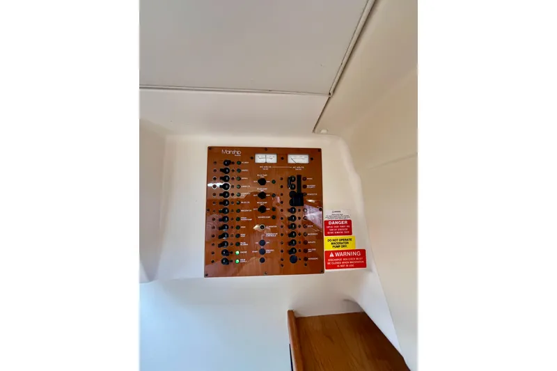 Slide: The Image of Electrical panel of 2005 Mainship Pilot 30-II boat with warning labels. - 33