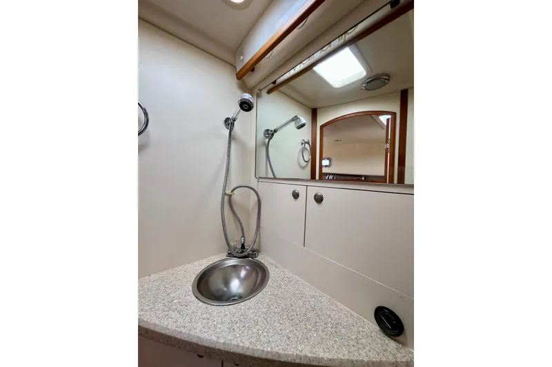 Slide: The Image of 2005 Mainship Pilot 30-II boat bathroom with sink, mirror, and showerhead. - 36