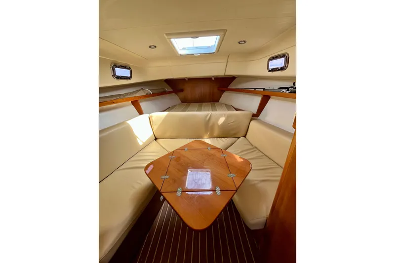 Slide: The Image of 2005 Mainship Pilot 30-II cabin interior with beige seating and wooden table. - 37