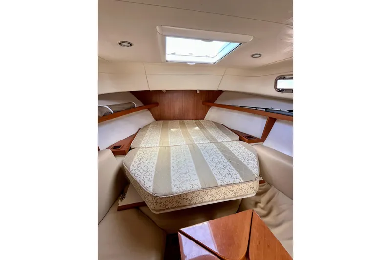 Slide: The Image of 2005 Mainship Pilot 30-II cabin interior with bed, wood accents, and skylight. - 41