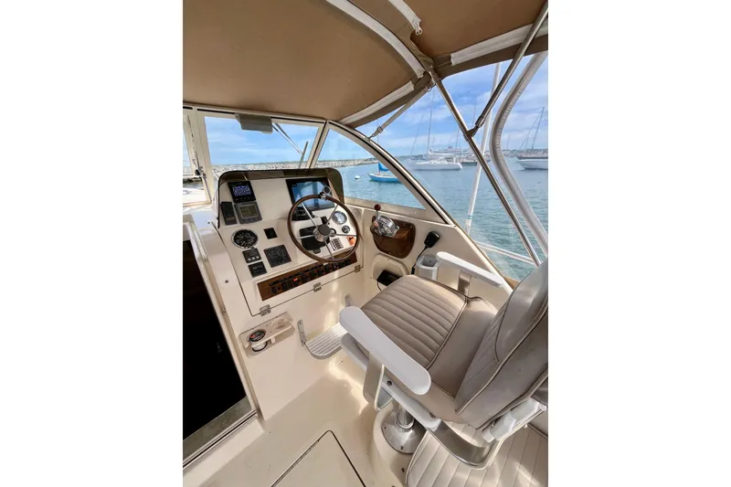 Slide: The Image of 2005 Mainship Pilot 30-II helm with steering wheel, controls, and ocean view. - 8