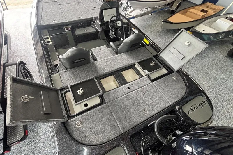 Slide: The Image of 2025 Falcon Boats 21 Predator interior with open storage compartments and Garmin electronics. - 10