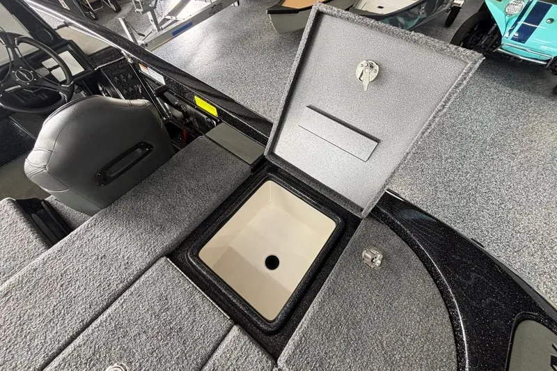 Slide: The Image of 2025 Falcon Boats 21 Predator interior with open storage compartment and steering wheel. - 11