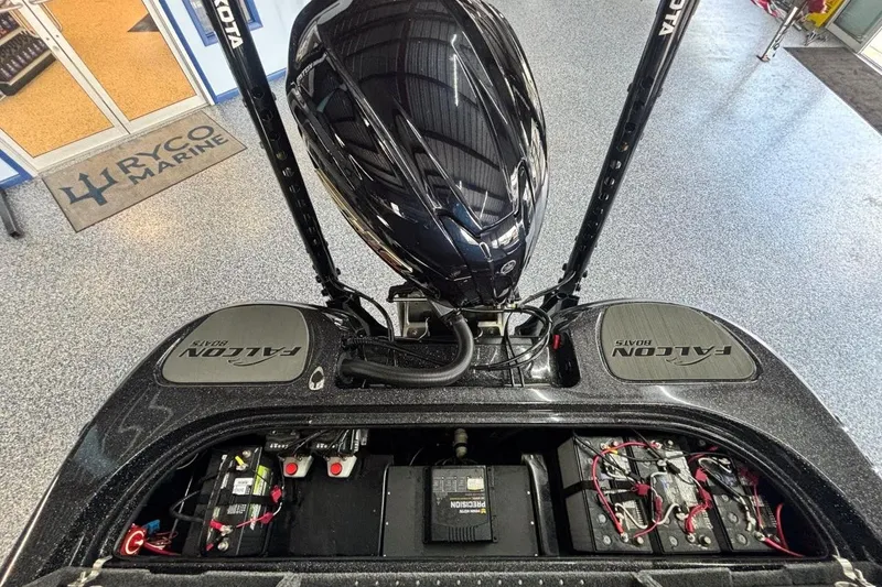 Slide: The Image of 2025 Falcon Boats 21 Predator with motor and battery compartments visible in showroom. - 18