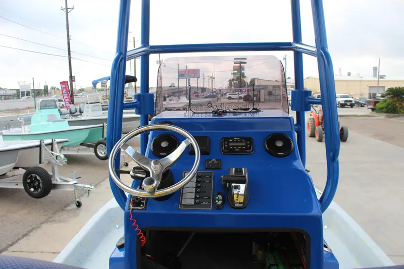 Slide: The Image of 2015 Shoalwater 23 Catamaran dashboard with steering wheel and controls, parked in a marina. - 11