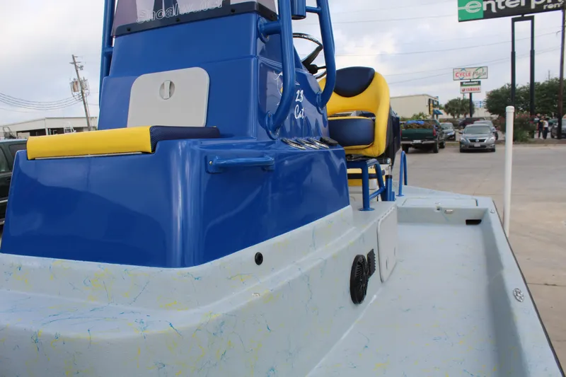 Slide: The Image of 2015 Shoalwater 23 Catamaran with blue and yellow seating, parked outdoors. - 14