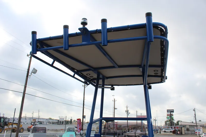 Slide: The Image of 2015 Shoalwater 23 Catamaran T-top frame, blue structure, outdoor setting. - 15