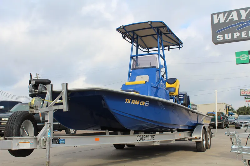 Slide: The Image of 2015 Shoalwater 23 Catamaran in blue on trailer, parked outdoors. - 3