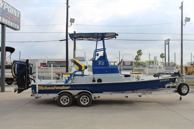 Slide: The Image of 2015 Shoalwater 23 Catamaran on trailer, blue and white, parked outdoors. - 4