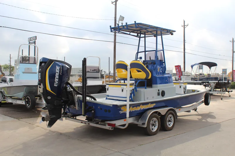 Slide: The Image of 2015 Shoalwater 23 Catamaran with Evinrude engine on trailer, parked outdoors. - 5