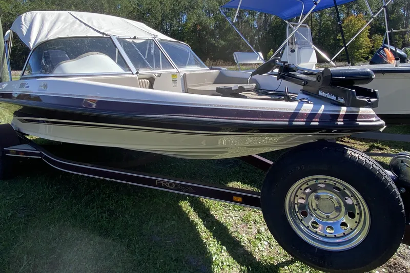 Slide: The Image of 2001 ProCraft 180 Combo boat on trailer, parked on grass, with canopy and MotorGuide trolling motor. - 1