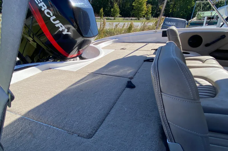 Slide: The Image of 2001 ProCraft 180 Combo boat interior with Mercury engine, featuring cushioned seating and carpeted deck. - 14